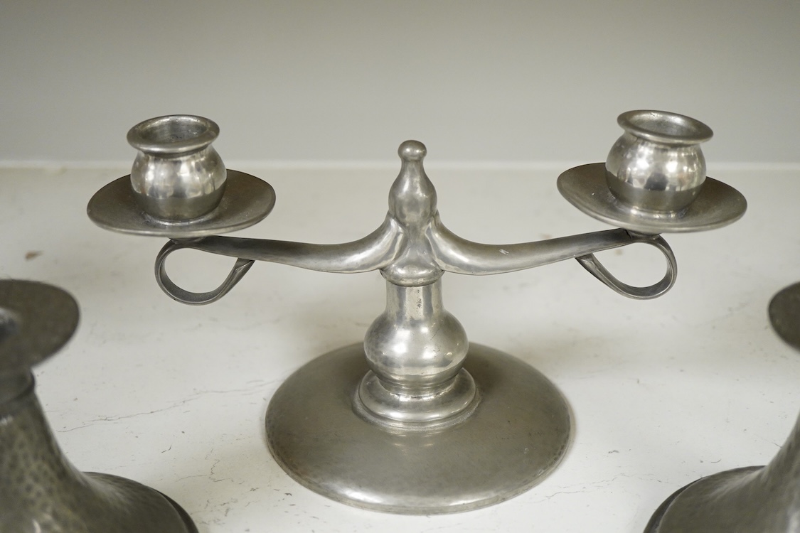 A Liberty Tudric pewter two branch candlestick, 22cm wide and two hammered candle holders.